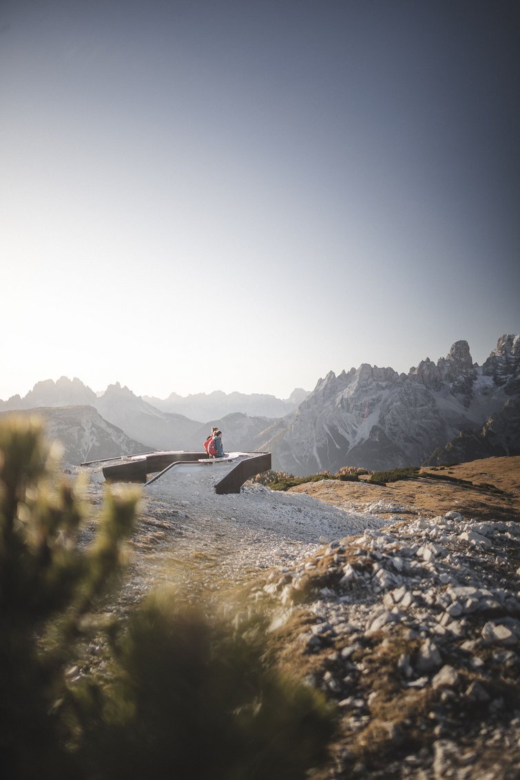 Persone che godono della vista da una piattaforma in montagna al tramonto
