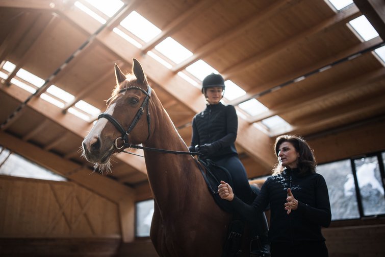 Dove fare equitazione in Alto Adige: hotel con maneggio Lezione di equitazione in una scuderia con cavalla e istruttrice