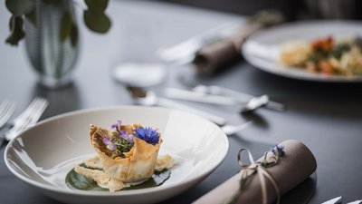 Piatto artistico con fiori commestibili su tavolo apparecchiato