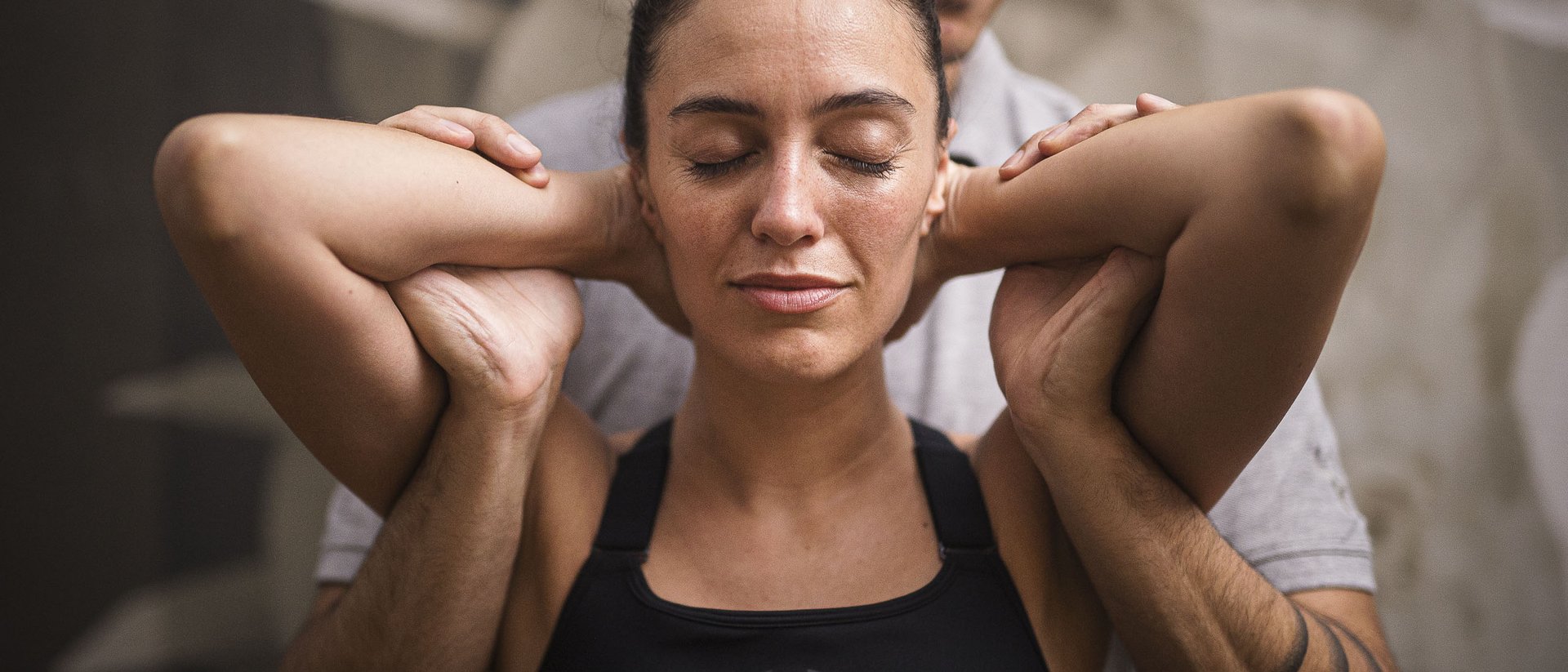 Donna che fa stretching aiutata da un istruttore