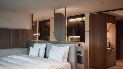 Photos from your hotel in Pfalzen in Val Pusteria/Pustertal Modern hotel room with double bed and integrated wooden furniture design