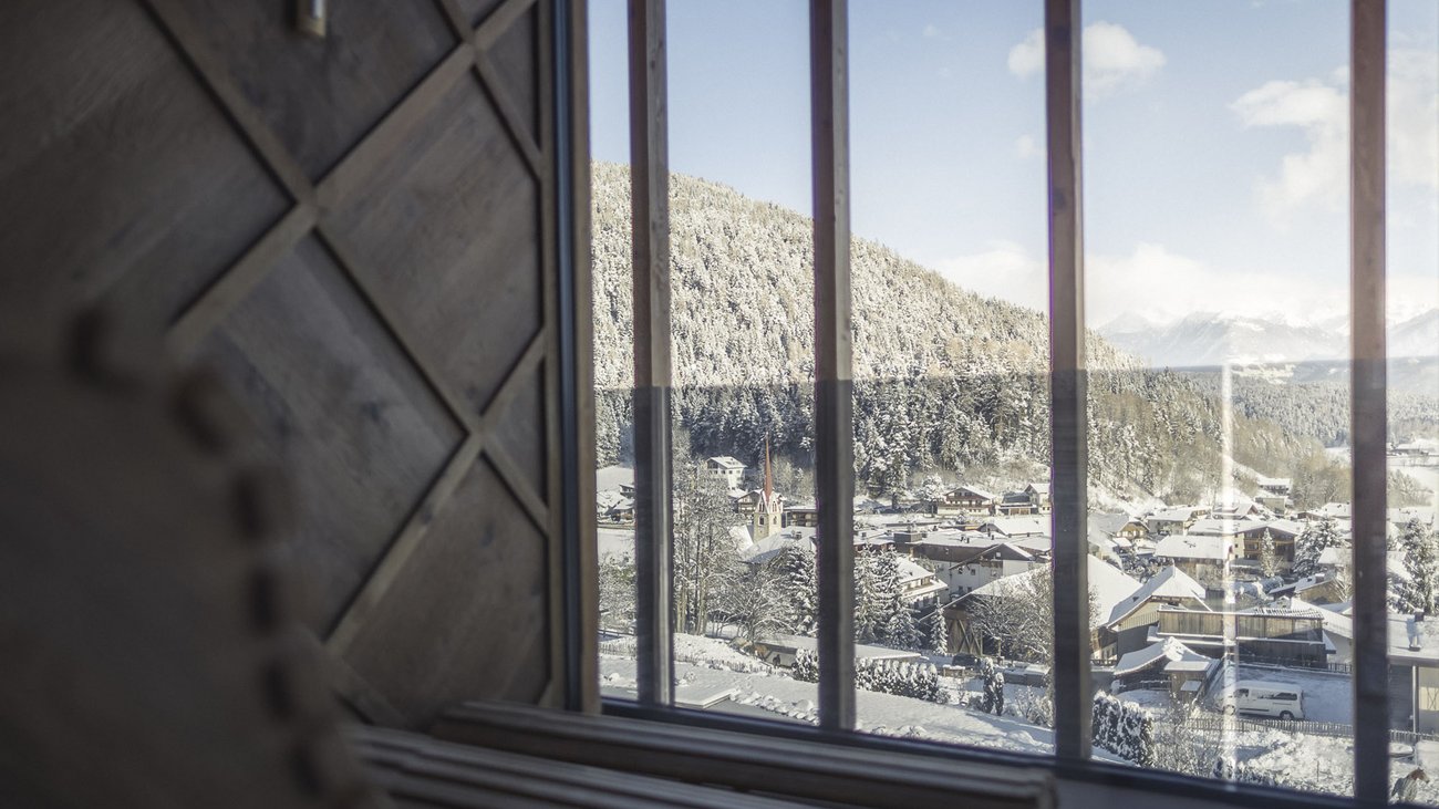 Villaggio di montagna innevato visto attraverso una grande finestra