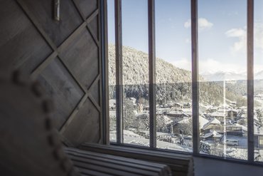 Villaggio di montagna innevato visto attraverso una grande finestra
