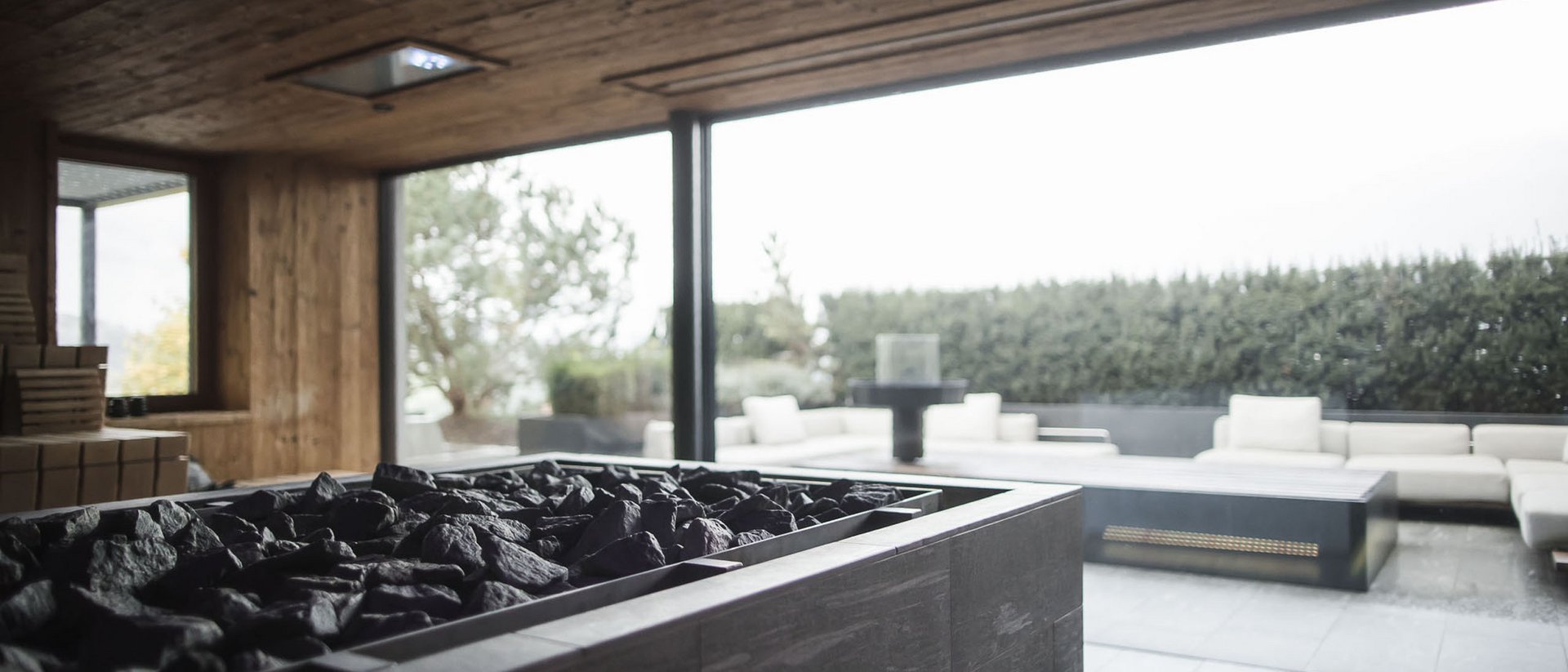 Modern indoor sauna stove with view of outdoor terrace seating area