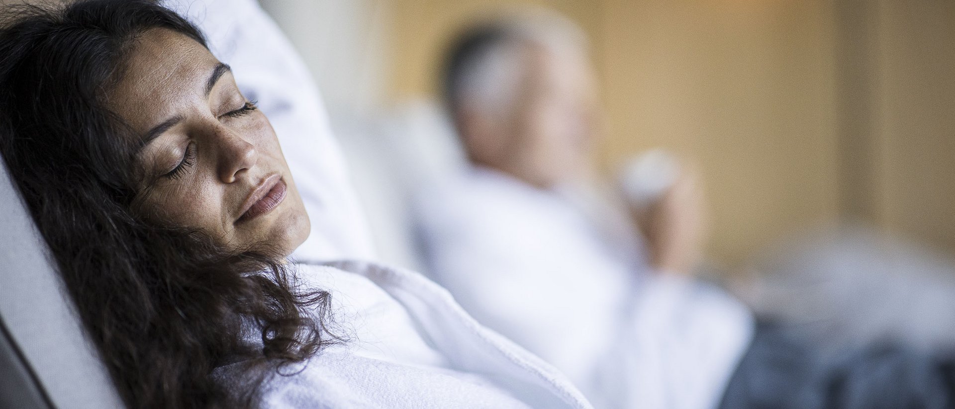 Woman relaxing in white robe with closed eyes