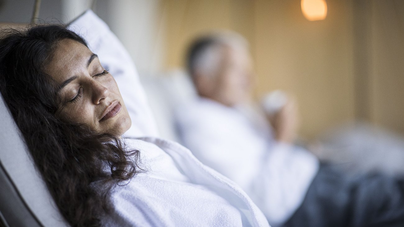 Woman relaxing in white robe with closed eyes
