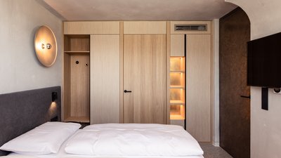 Camera da letto moderna con biancheria bianca e mobili in legno chiaro