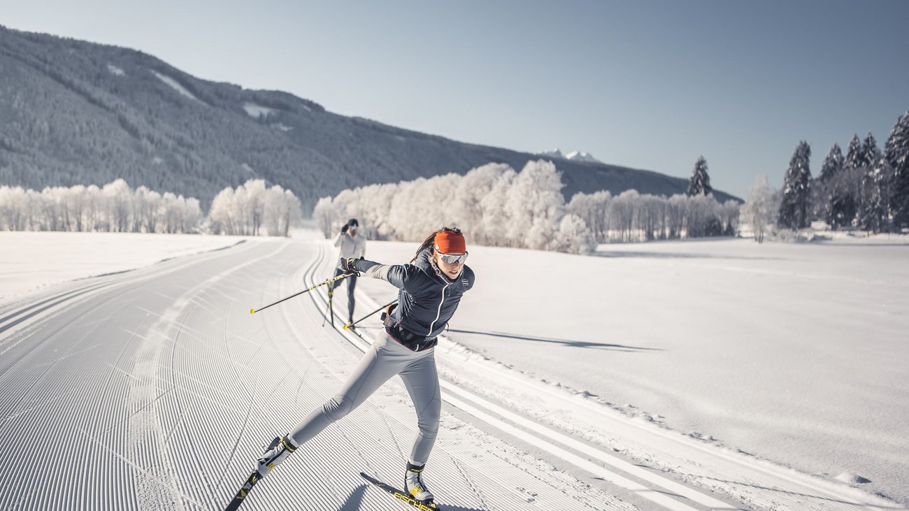 Due sciatori di fondo su pista appena preparata in una giornata invernale soleggiata