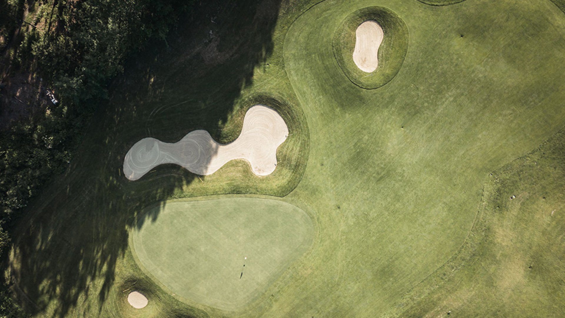 Aerial view of a golf course with sand bunkers and green areas