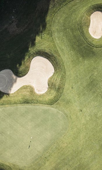 Drohnenaufnahme eines Golfplatzes mit Sandbunkern und Grünflächen