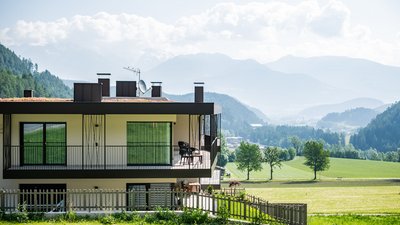 The best photos from our hotel in South Tyrol that kids love Modern house with balcony overlooking green fields and mountains in the background