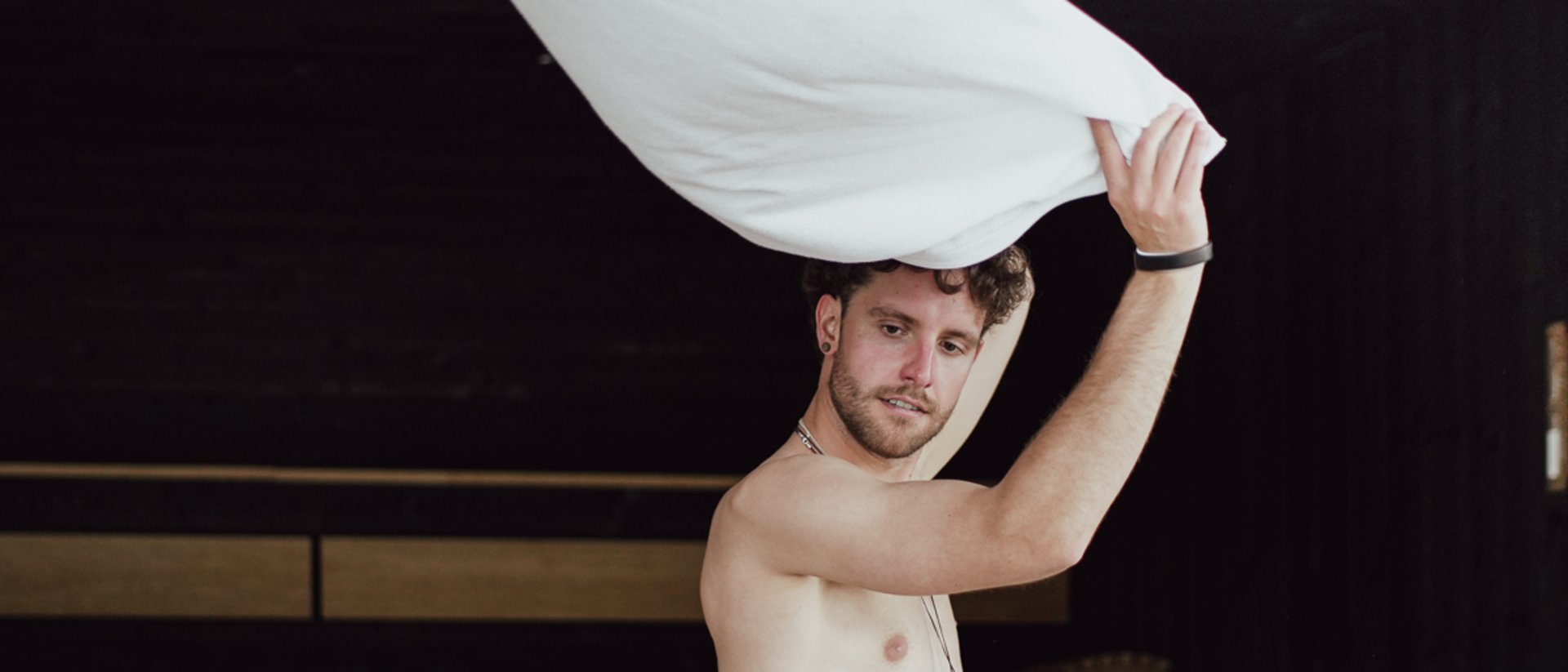 Man tossing a white towel in the air in a spa area