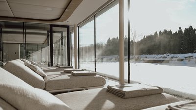 Photos from your hotel in Pfalzen in Val Pusteria/Pustertal Lounge chairs with towels by large window overlooking snowy landscape