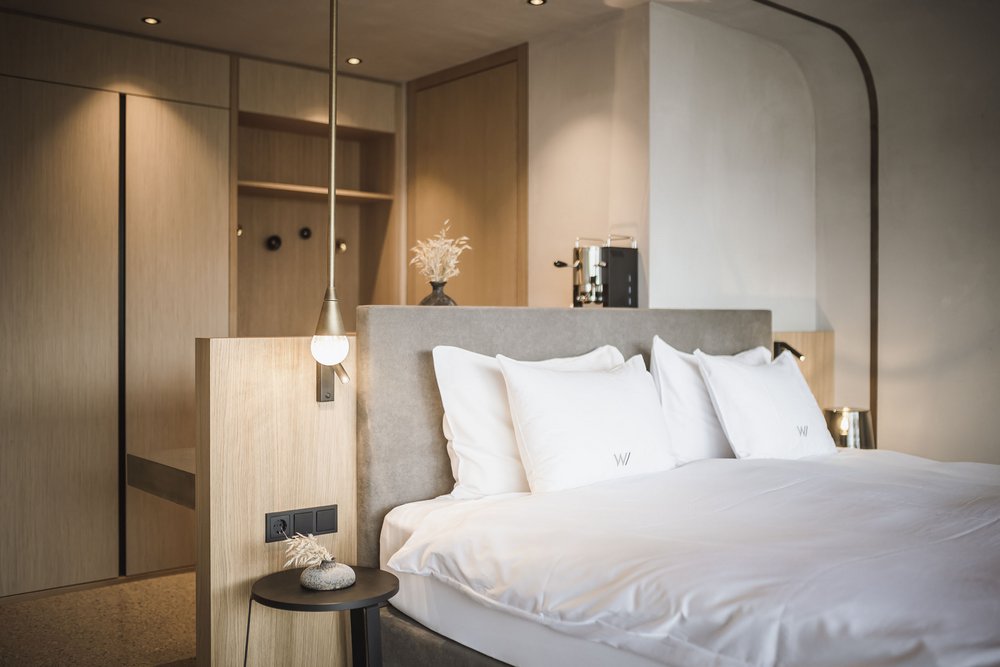 Modernes Hotelzimmer mit großem Bett und minimalistischer Einrichtung