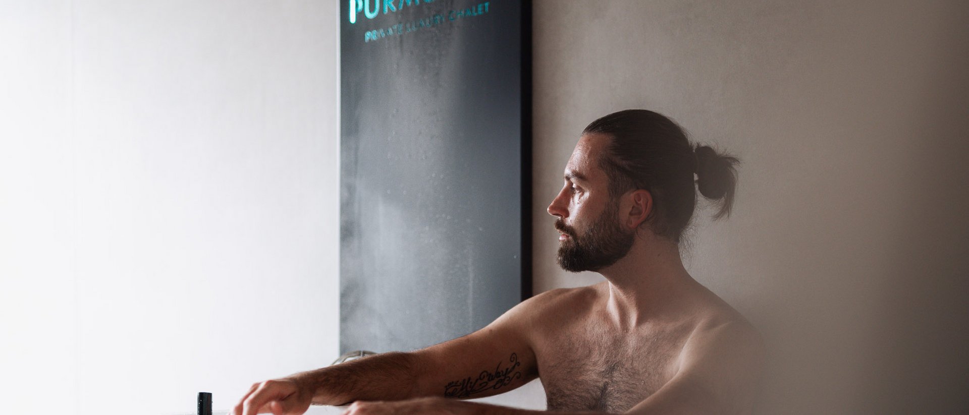 Mann entspannt in einer Sauna neben W Purmontes Schild