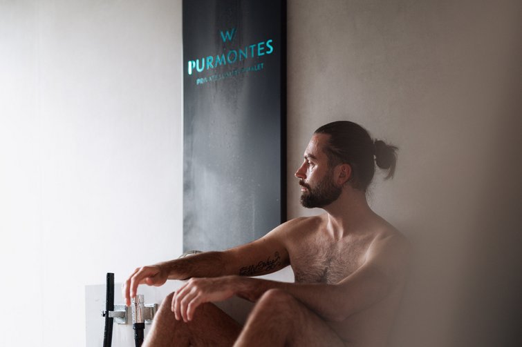 Mann entspannt in einer Sauna neben W Purmontes Schild