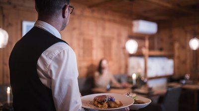 The best photos from our hotel in South Tyrol that kids love Waiter serving plates of food in a cozy restaurant