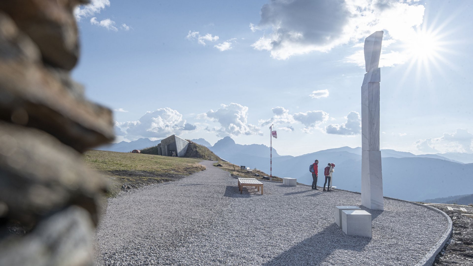 Avventure straordinarie nel nostro sporthotel in Alto Adige Escursionisti in montagna guardano una scultura con cielo soleggiato e montagne