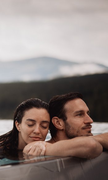 Couple relaxing in pool with mountain view in background