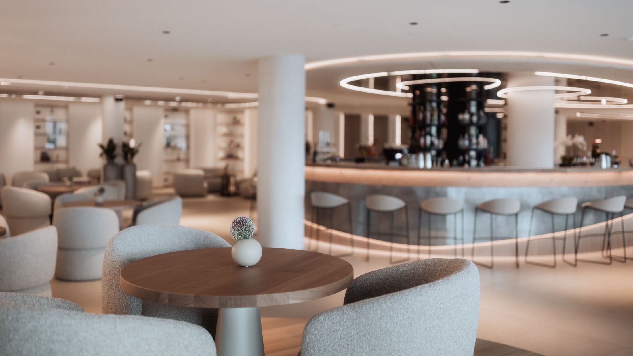 Moderner Lounge-Bereich mit rundem Tisch und Bar im Hintergrund