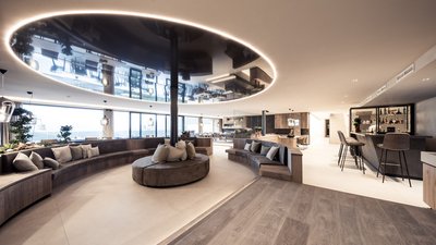 L’esclusività in foto: il nostro chalet in Alto Adige di lusso Lounge moderna con divani rotondi e bancone bar illuminato