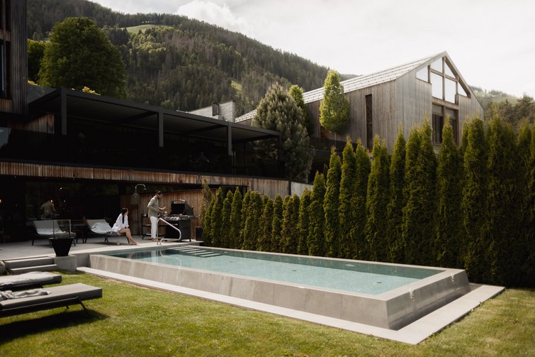 moderner pool im garten eines hauses mit bergen im hintergrund