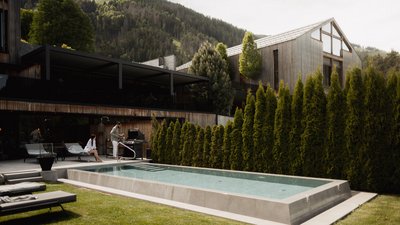 L’esclusività in foto: il nostro chalet in Alto Adige di lusso piscina moderna nel giardino di una casa con montagne sullo sfondo