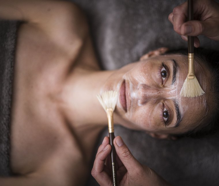 Relax e recupero nei Winklerhotels Donna riceve una maschera viso applicata con pennelli in una spa