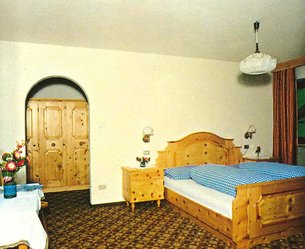 Rustic bedroom with wooden furniture and checkered bedspread