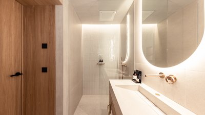 Bagno moderno con specchio illuminato e doccia walk-in