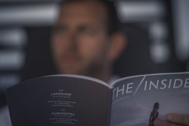 Eine regenerierende Auszeit vor Weihnachten Person liest Magazin THE INSIDER in unscharfem Hintergrund