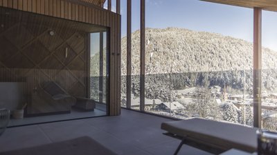 L’esclusività in foto: il nostro chalet in Alto Adige di lusso Balcone con vista su bosco innevato e villaggio in inverno