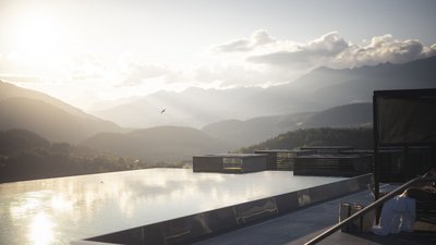 Piscina a sfioro con vista sulle montagne al tramonto