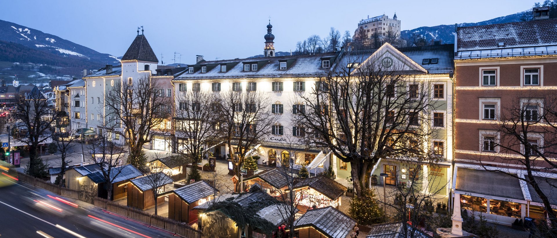 Mercatino di Natale in città storica al crepuscolo con edifici illuminati