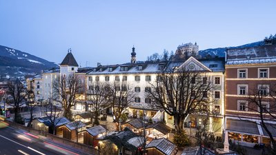Mercatino di Natale in città storica al crepuscolo con edifici illuminati