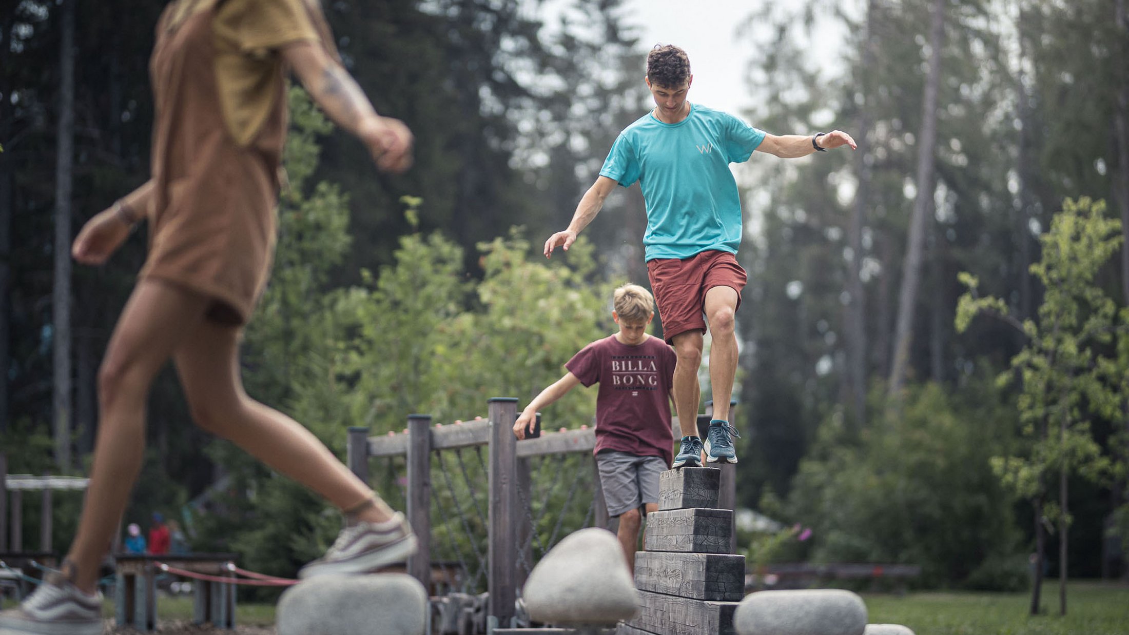 Bambini che fanno equilibrio su un percorso a ostacoli in legno e pietre nel parco