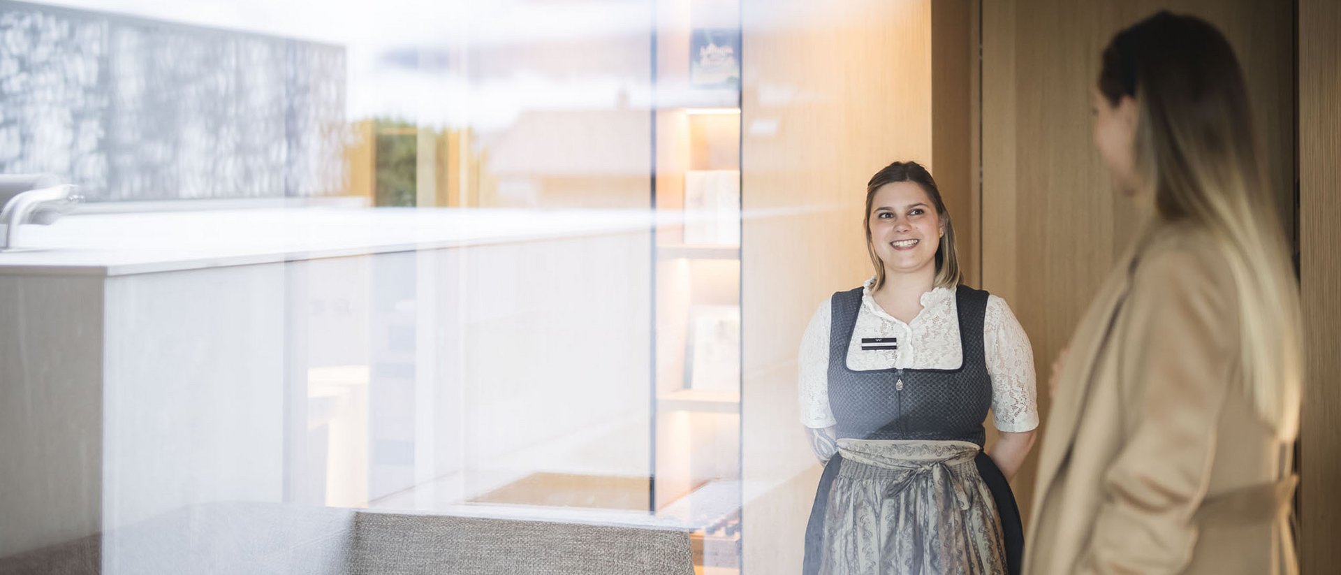 Young woman in traditional dress talking to another woman indoors