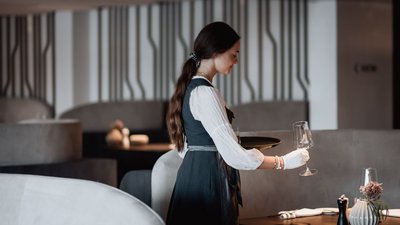 Waitress carrying wine glasses in a modern restaurant
