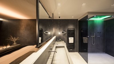 Bagno moderno con doppio lavabo e soffione doccia illuminato di verde