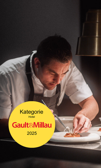 Chef carefully plating dish in fine dining kitchen with Gault&Millau Hotel category 2025