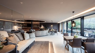 L’esclusività in foto: il nostro chalet in Alto Adige di lusso Soggiorno moderno con divano, tavolo da pranzo e ampie finestre con vista