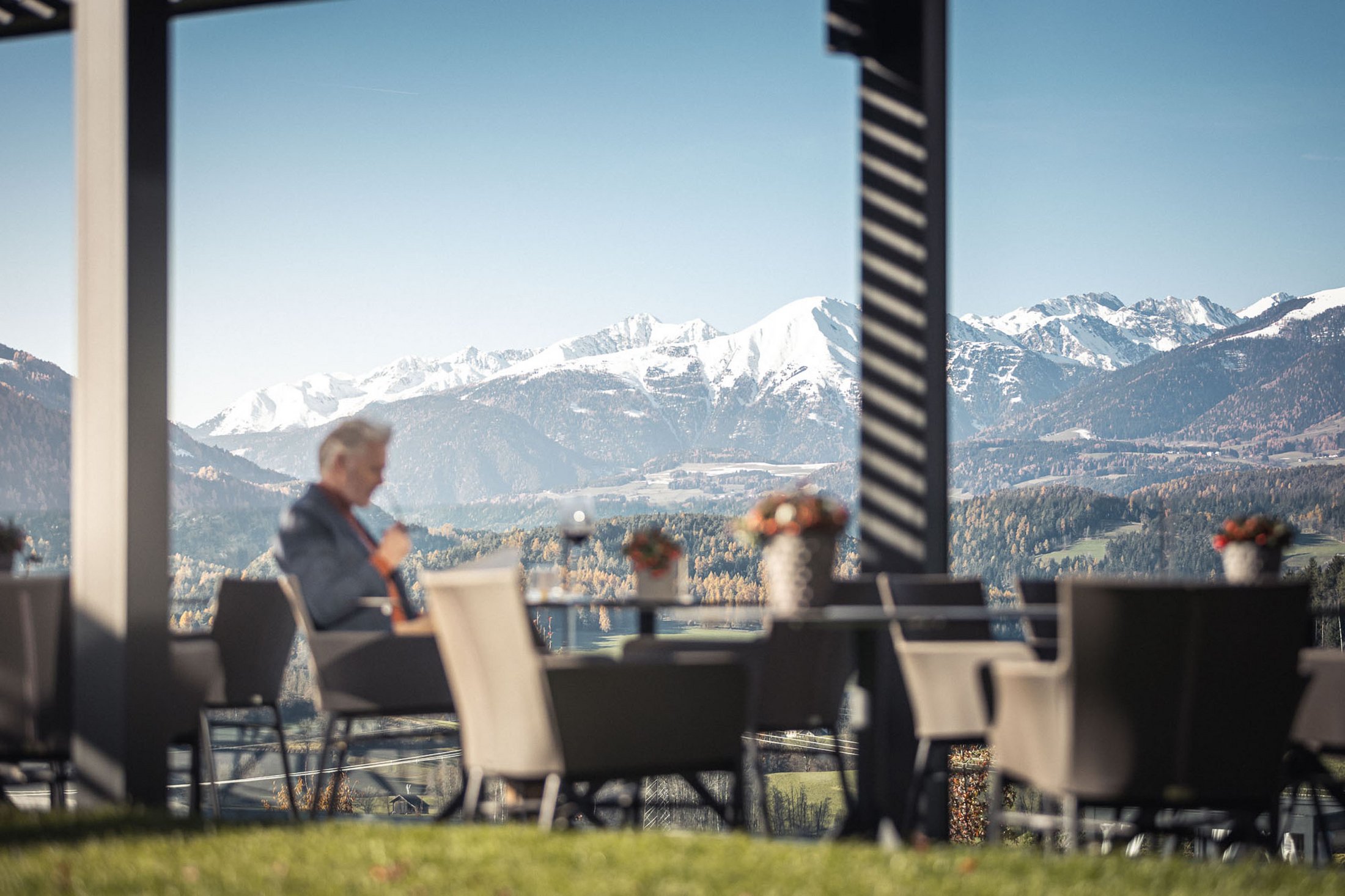 Man sitting outdoors on terrace drinking coffee with mountain view