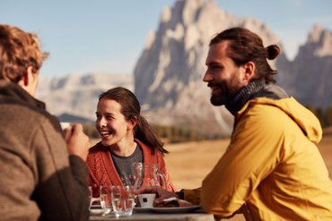 Eine regenerierende Auszeit vor Weihnachten Drei Freunde genießen Kaffee und Kuchen mit Bergpanorama im Hintergrund