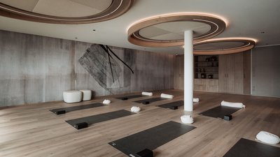 Photos from your hotel in Pfalzen in Val Pusteria/Pustertal Modern yoga room with mats, blocks, and round cushions on wooden floor