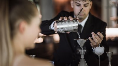 Bartender filtra una bevanda per la cliente al bancone