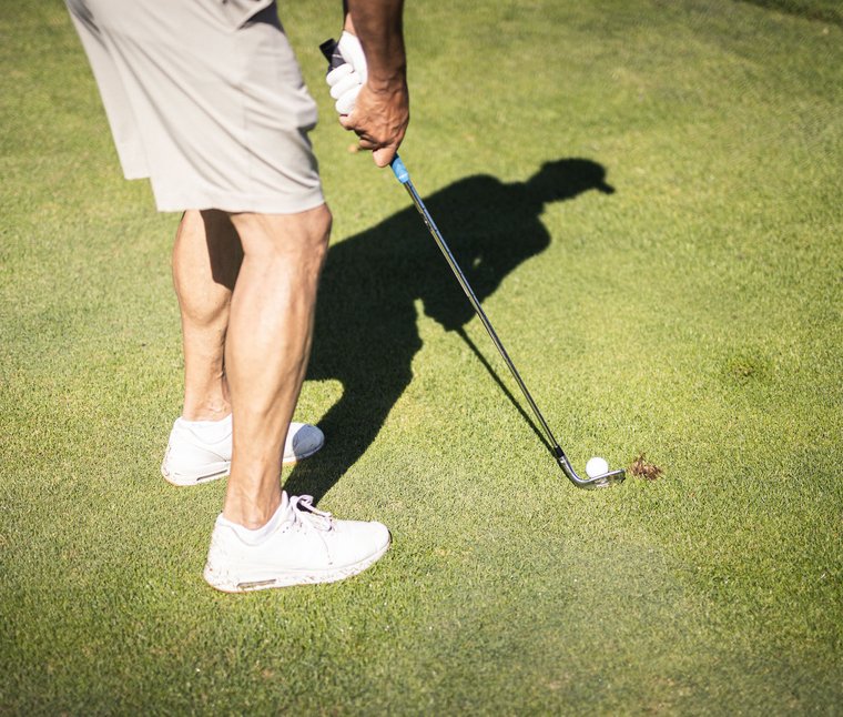 Giocatore di golf pronto a colpire la pallina sul campo