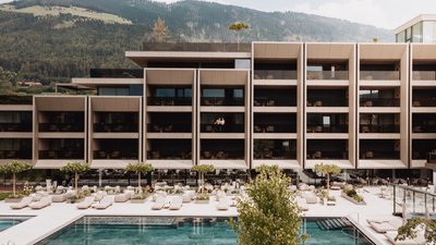 Photos from your hotel in Pfalzen in Val Pusteria/Pustertal Modern hotel with pool and loungers in front of forested mountain view