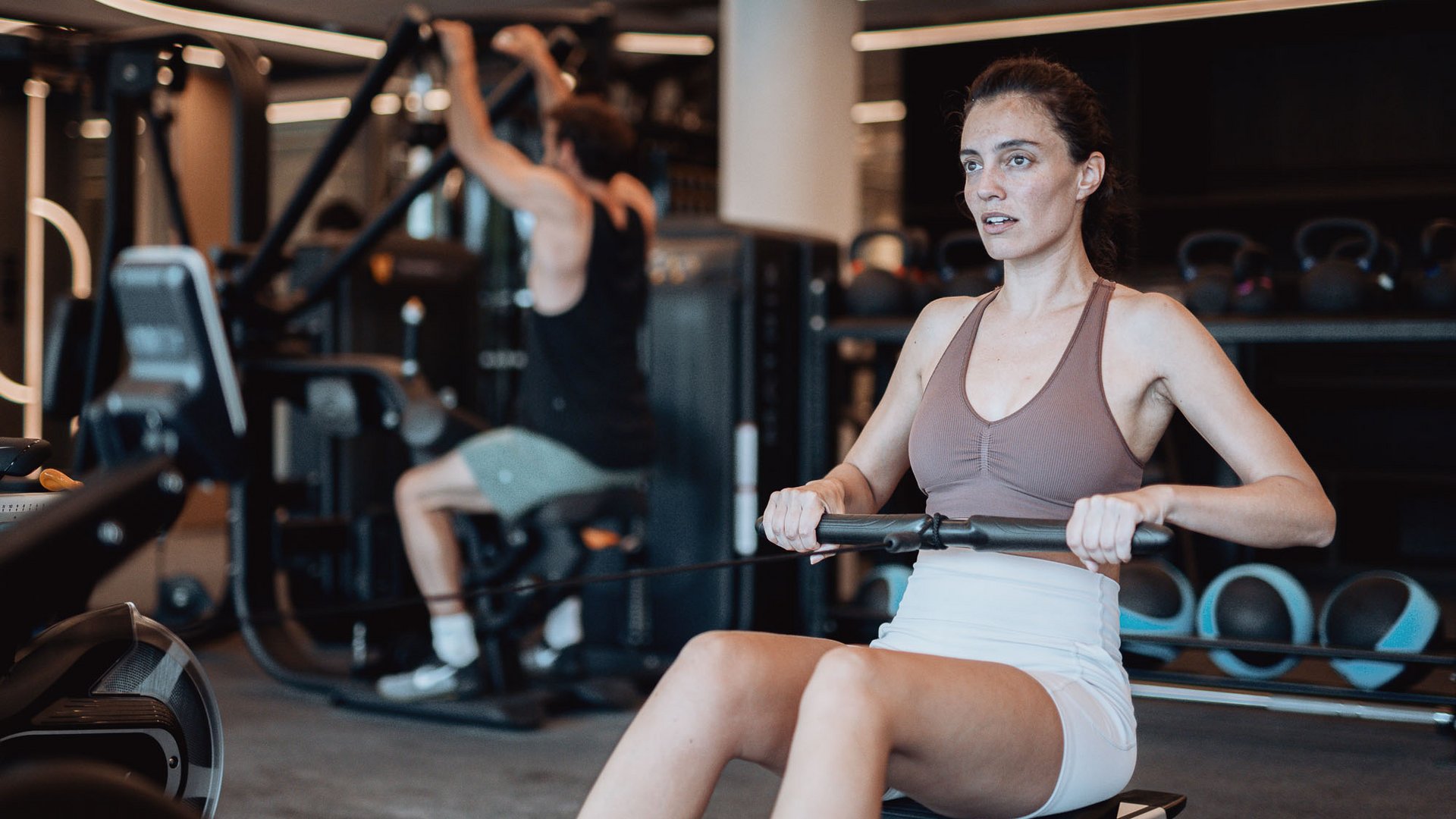 Frau trainiert auf Rudermaschine im Fitnessstudio
