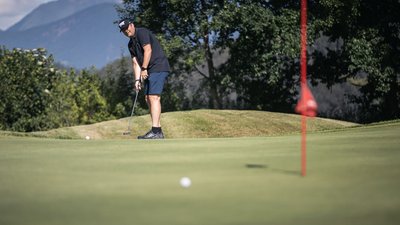 Uomo gioca a golf e fa un putt vicino alla buca sul green