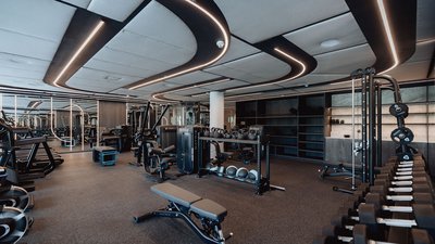 Moderne Fitnessstudio mit Hanteln und Trainingsgeräten unter stilvoller Beleuchtung
